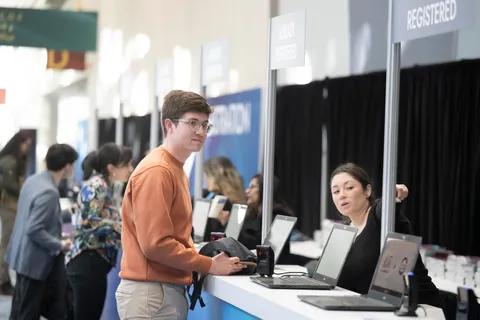 An attendee checks in at the registration desk. 